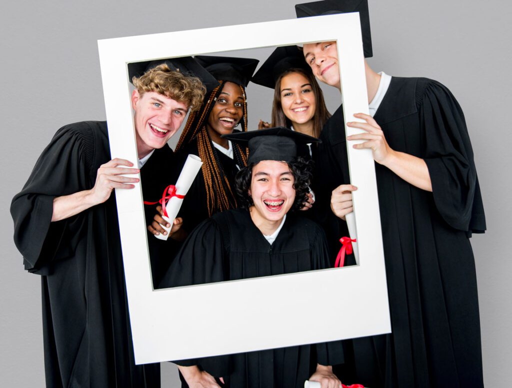 high school graduates posing behind giant polaroid frame