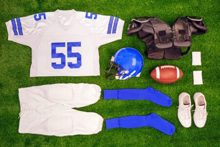 school football uniform and protective equipment laying on field